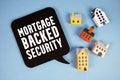 Mortgage-backed Security text with house models on blue background Royalty Free Stock Photo