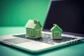 Mortgage concept with a house model on a laptop keyboard against a green nature background. Real estate, finance, and eco- Royalty Free Stock Photo