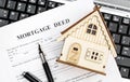 Mortgage deed with model of house on laptop keyboard. Top view Royalty Free Stock Photo