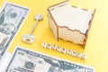 mortgage, insurance, loan and home purchase. Model of house, dollar bills, key on white and yellow isolated background. Free space Royalty Free Stock Photo