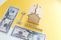 mortgage, insurance, loan and home purchase. Model of house, dollar bills, key on white and yellow isolated background. Free space Royalty Free Stock Photo