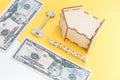 mortgage, insurance, loan and home purchase. Model of house, dollar bills, key on white and yellow isolated background. Free space Royalty Free Stock Photo