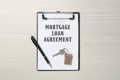 Mortgage loan agreement, house key and pen on white wooden table, top view Royalty Free Stock Photo