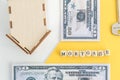 mortgage, loan and home purchase. Model of house, dollar bills, key on white and yellow isolated background. Free space for text, Royalty Free Stock Photo