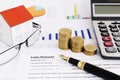 Mortgage loans concept with close up business fountain pen and money coins stack and calculator and paper house and eyeglasses on Royalty Free Stock Photo