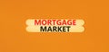 Mortgage market symbol. Concept words Mortgage market on beautiful wooden stick. Beautiful orange table orange background.