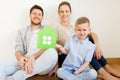 Happy family with green house moving to new home Royalty Free Stock Photo