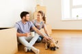 Happy couple with boxes and dog moving to new home Royalty Free Stock Photo