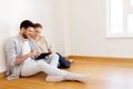 Happy couple with tablet pc computer at new home