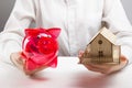 Mortgage or savings concept. hands holding money box and miniature house Royalty Free Stock Photo