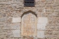 mortgaged window in the mosque. Window with inscriptions. A wall of limestone and cement