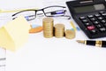 Fountain pen and coins stack and yellow hose paper and eyeglasses