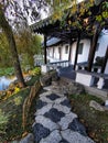 A mosaic-laid footpath with oriental building and duck pond at the Lan Yuan Chinese Gardens in Dunedin, New Zealand