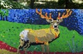 Mosaic with a red deer or cervus elaphus figure made of waste plastic caps