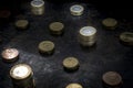 Mosaic with a regular pattern made up of euro coins on a dark black background metal details