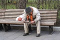 a homeless elderly man is sitting on a park bench