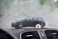 Moscow. Autumn 2018. Black toy car stays in smoke on dashboard of the same real car. Volkswagen golf 6, logo mat vw