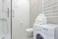 Bright bathroom with shower, toilet, washing machine and white towels 0074