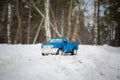 Moscow. December 2018. Blue toy Pickup truck Ford F350 in snow forest. Carrying fir cones. Winter offroad