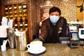 Moscow December 15 2020. Young Barista guy in medical mask drops a Cup of coffee editorial