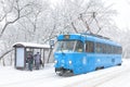 Tram during snowstorm in winter Moscow, Russia. People wait the urban transport on ice stop. Cold and snowfall in city