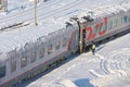 MOSCOW, FEB. 01, 2018: Winter day view on railway passenger coaches cars under snow and ice on roofs. Maintenance worker in high-v