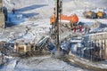 MOSCOW, FEB. 01, 2018: Winter view on dirty heavy construction equipment, vehicles and workers at work. Drilling operations on con