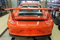 Moscow. February 2019. Back side view of a new orange metallic Porsche 911 GT3 RS in an interactive dealership maintenance box.