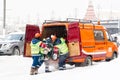 Workers load snow removal equipment in a van