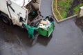 Garbage workers in residential area, garbage men loading household rubbish in garbage truck