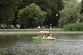 Family ride a catamaran on the pond in the park