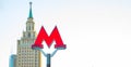 Moscow metro sign and Stalinist architecture on background Royalty Free Stock Photo
