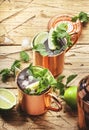 Moscow mule cocktail in copper mug with lime, ginger beer, vodka and mint. Wooden table, top view, copy space Royalty Free Stock Photo