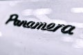 Moscow. November 2018. Porsche Panamera emblem logo in black on white dirty car. ME in focus