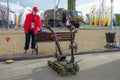 A remotely controlled military sapper robot serves a bottle of water to a volunteer girl