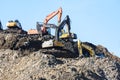 MOSCOW REGION, RUSSIA, MARCH 26, 2020. A group of working excavators on a training ground against a blue sky