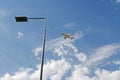 Street metal lamp post on blue sky background with airplane and clouds in Skolkovo