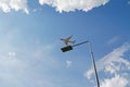 Street metal lamp post on blue sky background with airplane and clouds in Skolkovo