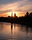 Moscow river, embankment and silhouettes of buildings and Kremlin towers on sunset