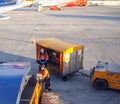 airport employees unload suitcases, passengers luggage from conveyor Royalty Free Stock Photo