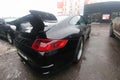 Moscow, Russia - April 22, 2019: A black Porsche 911 customized with aerodynamic kit and carbon spoiler stands in the parking lot