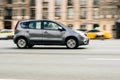 Fast moving gray car on the city road. Compact city hatchback with an elderly man driving. Nissan Note on the city street in Royalty Free Stock Photo