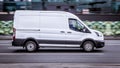 Ford Transit Fourth generation in the city street. Side view of white light commercial vehicle Royalty Free Stock Photo