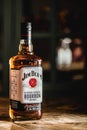 Jim Beam bourbon bottle on wooden table in dark bar