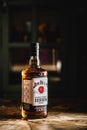 Jim Beam bourbon bottle on wooden table in dark bar