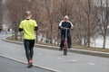 Moscow. Russia. April 9, 2019. A man on a bicycle goes to meet a man who commits a run. Sports leisure in Moscow