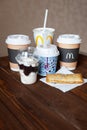 Moscow, Russia - April 06, 2019: McDonald`s food delivery. Desserts and hot drinks on wooden table. Close-up. Side view. Vertical