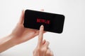 Moscow, Russia, 28 April, 2020. Netflix application logo on screen of Iphone X on white backdrop. Netflix app icon on smartphone