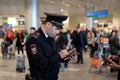 A police officer checks the documents of passengers on a laptop computer at the Moscow Domodedovo International Airport Royalty Free Stock Photo