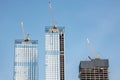 Moscow, Russia - April 13, 2021: Skyscraper construction. Construction cranes on the roofs of three high-rise buildings under